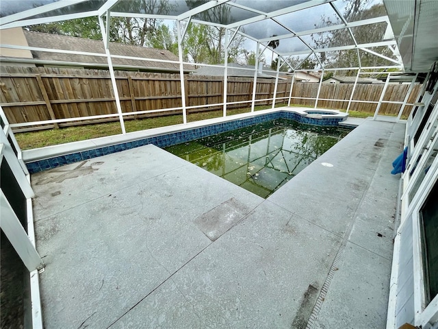 view of swimming pool featuring a pool with connected hot tub, a lanai, a fenced backyard, and a patio