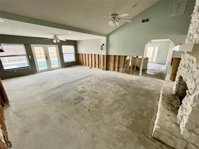 unfurnished living room with ceiling fan, high vaulted ceiling, and visible vents