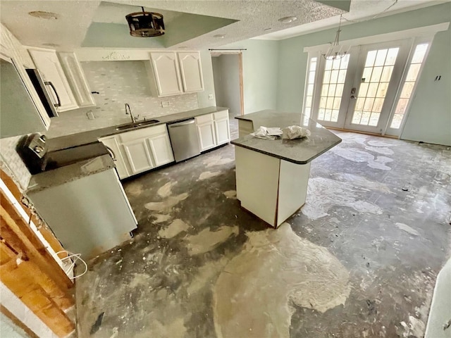 kitchen with tasteful backsplash, a textured ceiling, stainless steel dishwasher, white cabinetry, and a sink