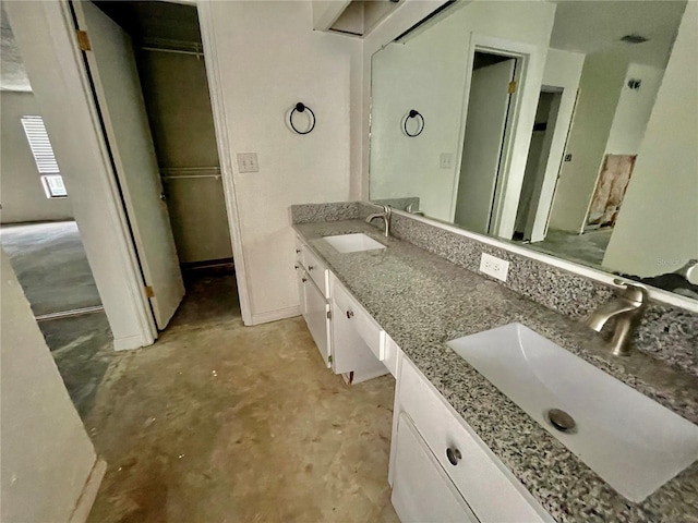 full bath with double vanity, unfinished concrete flooring, and a sink
