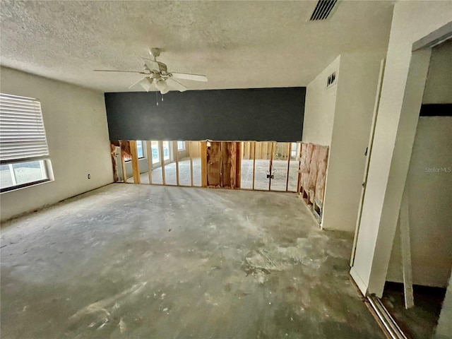 empty room with a ceiling fan, visible vents, unfinished concrete flooring, and a textured ceiling