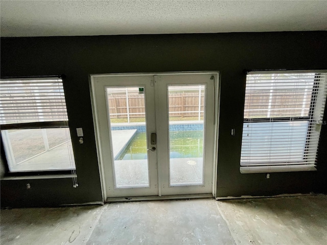 doorway to outside featuring a textured ceiling and french doors