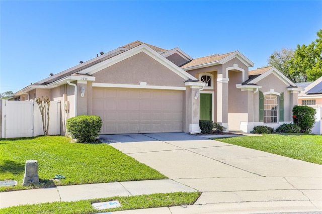 view of front of house featuring an attached garage, fence, a front lawn, and stucco siding