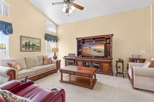 living room with ceiling fan, a textured ceiling, carpet flooring, and a healthy amount of sunlight