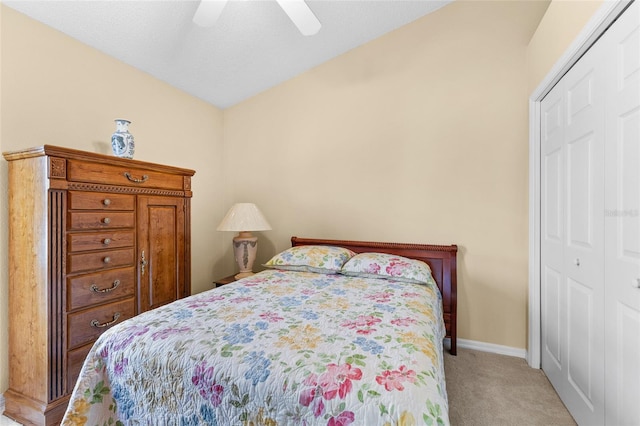 bedroom featuring a ceiling fan, a closet, light carpet, and baseboards