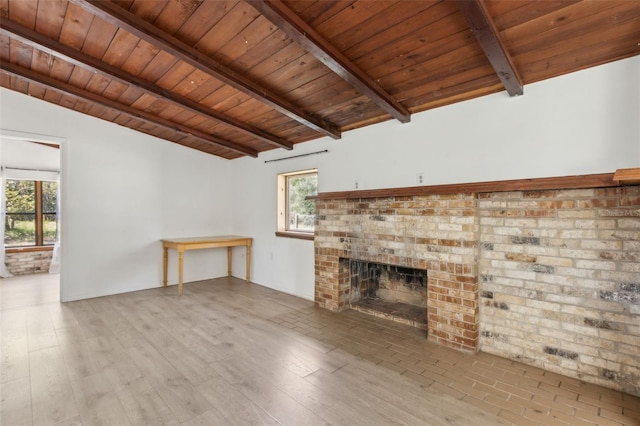 unfurnished living room with a brick fireplace, wood ceiling, lofted ceiling with beams, and wood finished floors