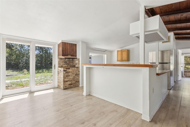 kitchen with lofted ceiling with beams, plenty of natural light, and light wood-style flooring