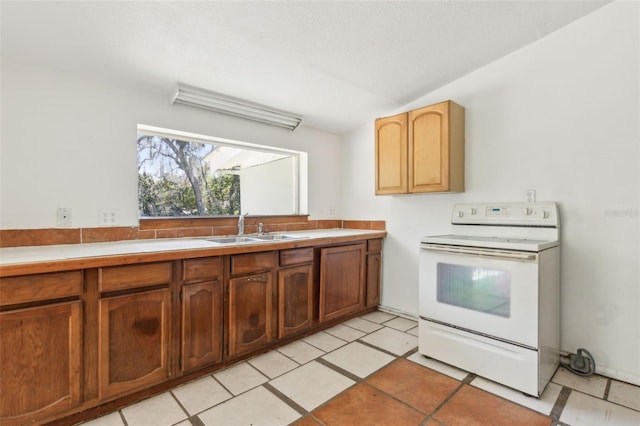 kitchen featuring electric range, a sink, brown cabinetry, light countertops, and lofted ceiling