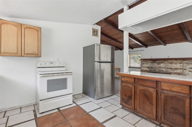 kitchen featuring visible vents, freestanding refrigerator, white electric stove, tile countertops, and wooden ceiling