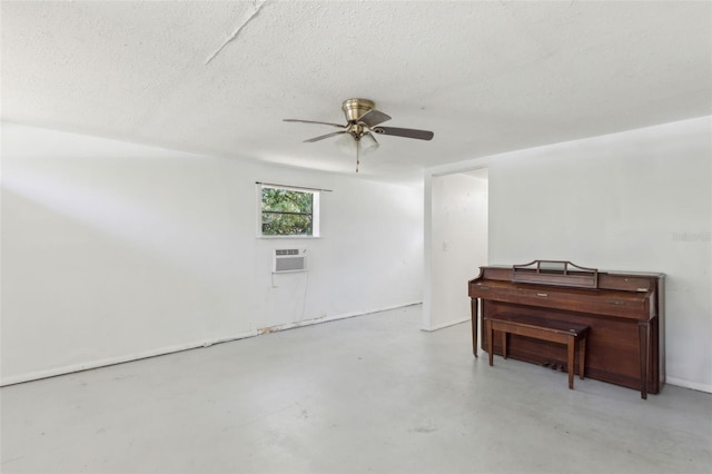 interior space with a wall mounted air conditioner, a textured ceiling, and ceiling fan