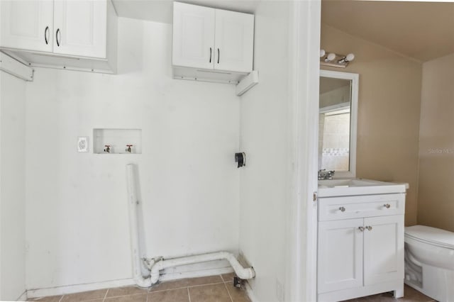 laundry area featuring tile patterned floors, a sink, laundry area, and washer hookup