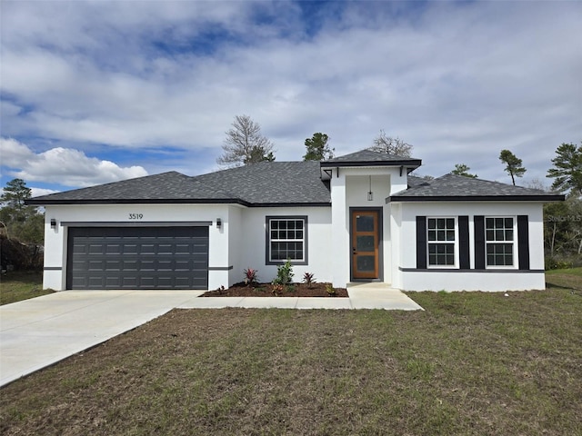 view of front of home with a front lawn, concrete driveway, an attached garage, and stucco siding