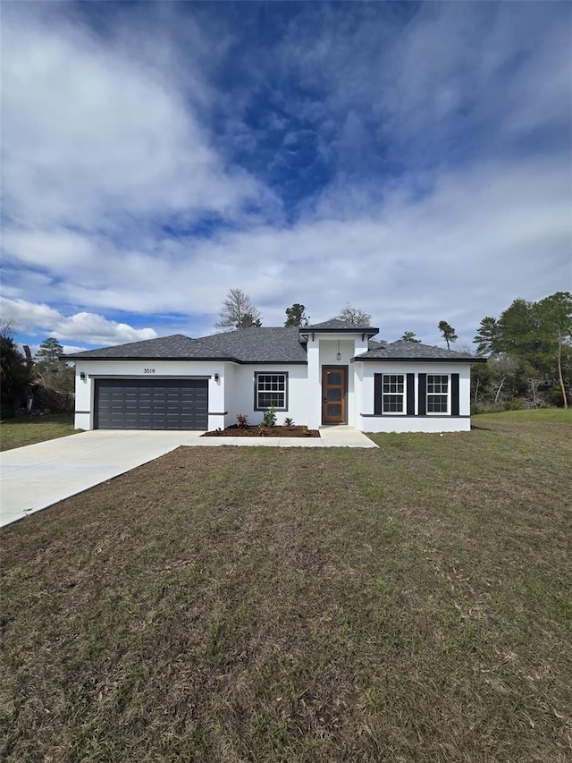 view of front facade featuring a front yard, concrete driveway, an attached garage, and stucco siding