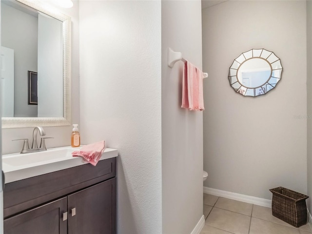 bathroom featuring baseboards, vanity, toilet, and tile patterned floors