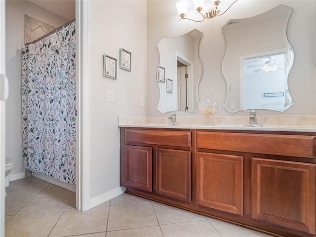 full bathroom featuring double vanity, toilet, a sink, and tile patterned floors