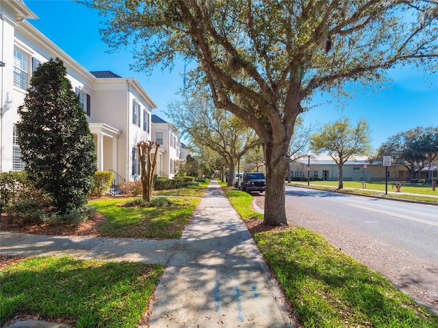 view of street featuring curbs, traffic signs, sidewalks, and a residential view