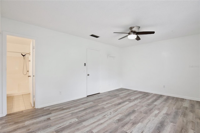 unfurnished room featuring ceiling fan, visible vents, baseboards, and wood finished floors