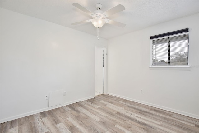 unfurnished room with ceiling fan, a textured ceiling, baseboards, and wood finished floors