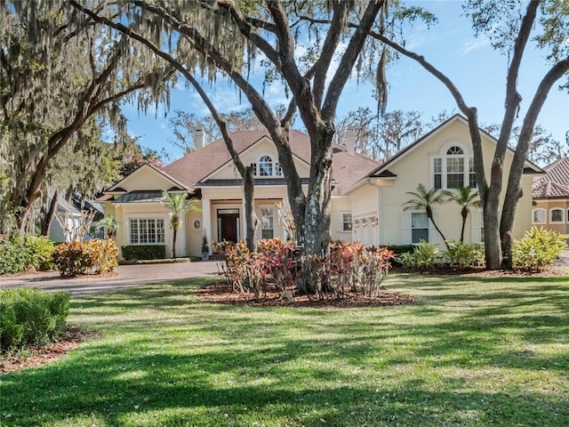 view of front of property featuring a chimney, a front lawn, and stucco siding