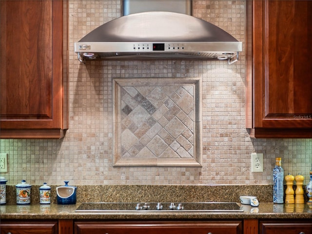 kitchen featuring dark countertops, wall chimney range hood, tasteful backsplash, and black electric cooktop