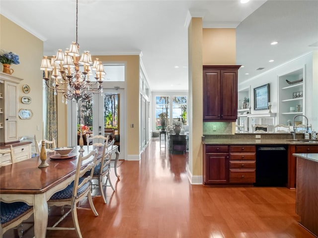 dining room with ornamental molding, light wood-style flooring, and baseboards