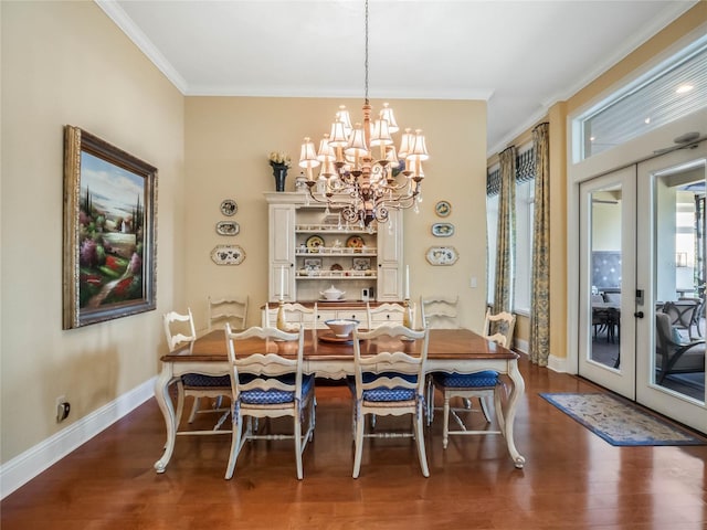 dining space with a chandelier, wood finished floors, baseboards, french doors, and crown molding