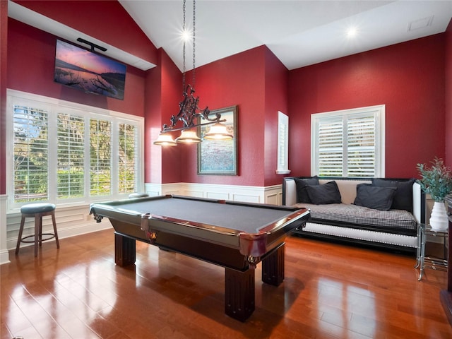 rec room featuring lofted ceiling, a decorative wall, wainscoting, wood finished floors, and billiards