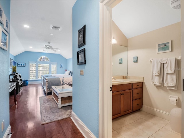 interior space with baseboards, visible vents, vaulted ceiling, and light wood finished floors