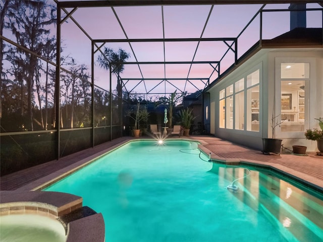 outdoor pool featuring a lanai, a patio area, and an in ground hot tub