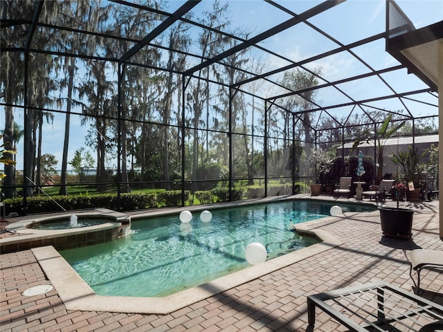 view of pool featuring a pool with connected hot tub, a lanai, and a patio