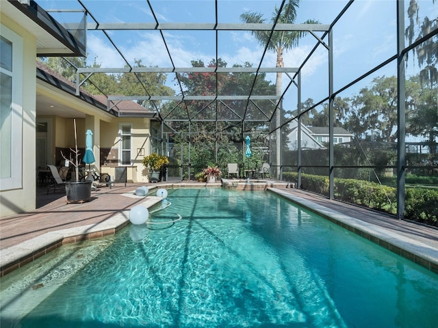 view of swimming pool with glass enclosure, a patio area, and a pool with connected hot tub