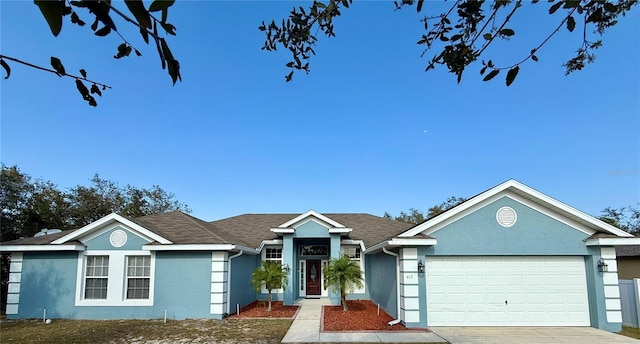 single story home with an attached garage, concrete driveway, and stucco siding