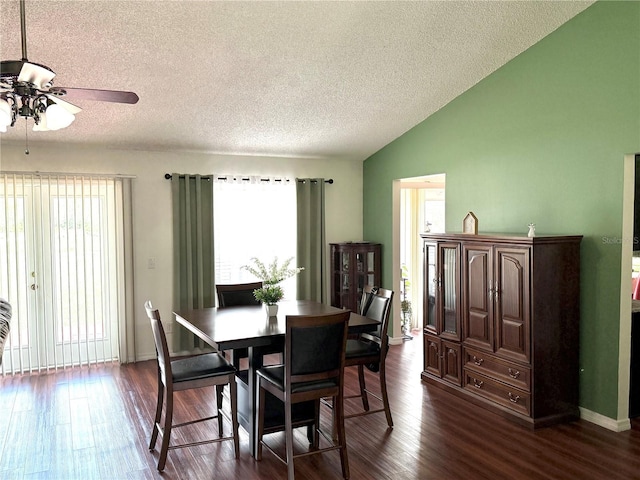 dining space featuring lofted ceiling, dark wood-style flooring, plenty of natural light, and a textured ceiling