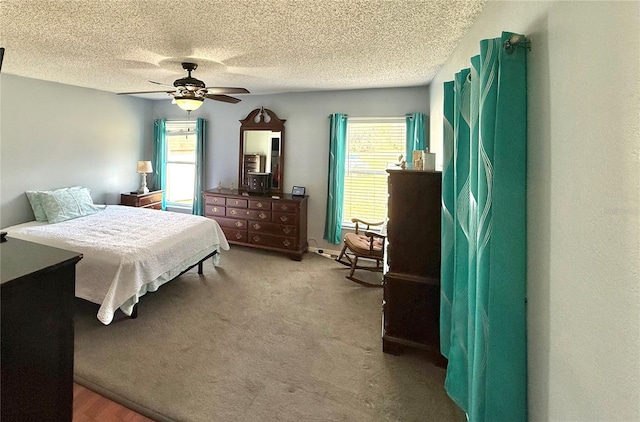 carpeted bedroom with ceiling fan and a textured ceiling