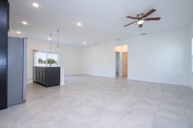 unfurnished living room with recessed lighting, ceiling fan, and baseboards