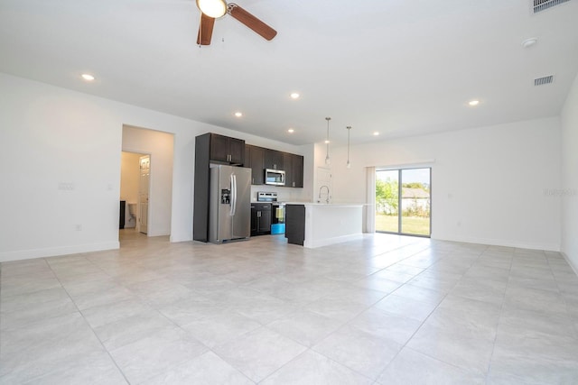 unfurnished living room featuring baseboards, visible vents, a sink, and recessed lighting