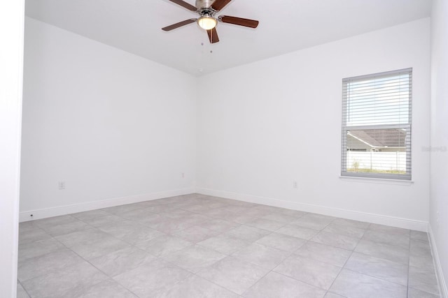 spare room featuring ceiling fan and baseboards