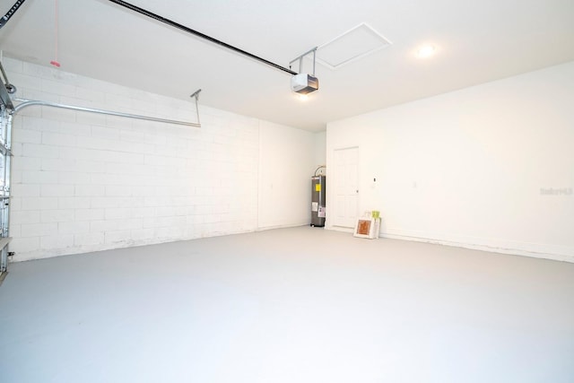 garage with concrete block wall, electric water heater, and a garage door opener