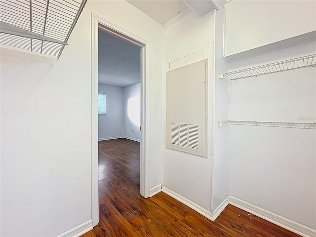 corridor featuring baseboards and wood finished floors