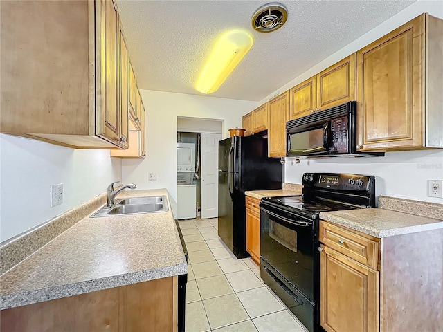 kitchen featuring light tile patterned floors, stacked washer and dryer, a textured ceiling, black appliances, and a sink