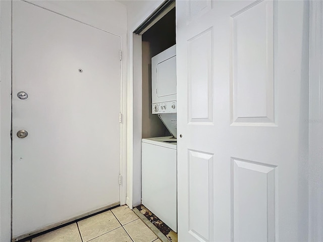 washroom with laundry area, light tile patterned floors, and stacked washer and clothes dryer