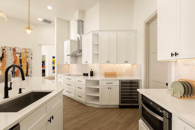 kitchen featuring wine cooler, a sink, visible vents, wall chimney exhaust hood, and open shelves