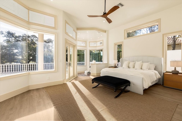 bedroom with multiple windows, visible vents, and wood finished floors