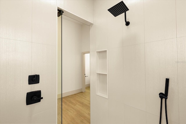 interior space featuring a tile shower and wood finished floors