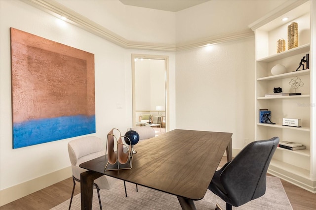 office featuring built in shelves, baseboards, and wood finished floors