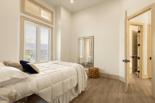 bedroom featuring wood finished floors and baseboards