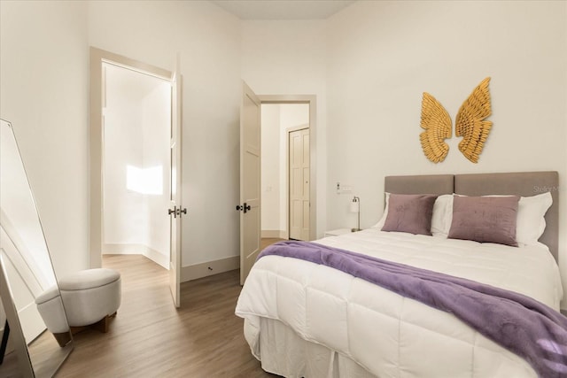 bedroom with baseboards and wood finished floors