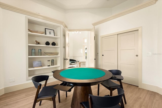 game room with light wood-type flooring and built in shelves