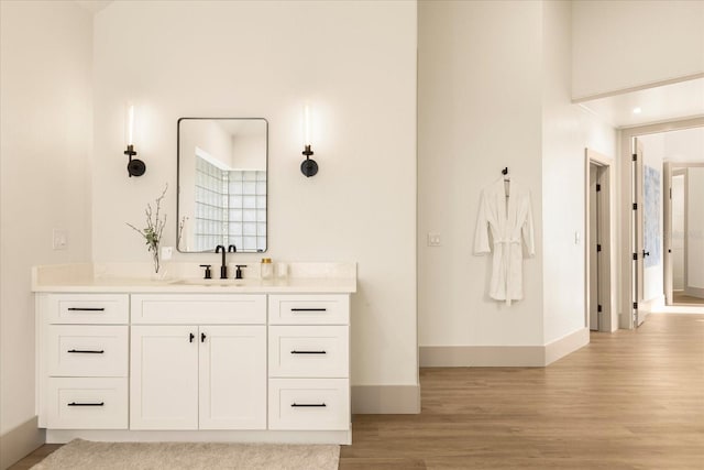 bathroom with baseboards, wood finished floors, and vanity