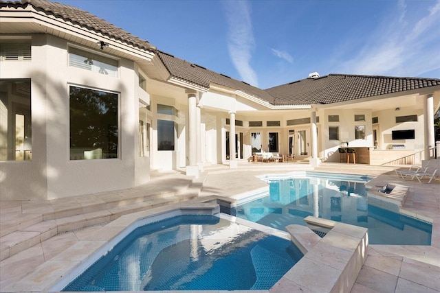 view of swimming pool featuring outdoor dry bar, a patio, and a pool with connected hot tub